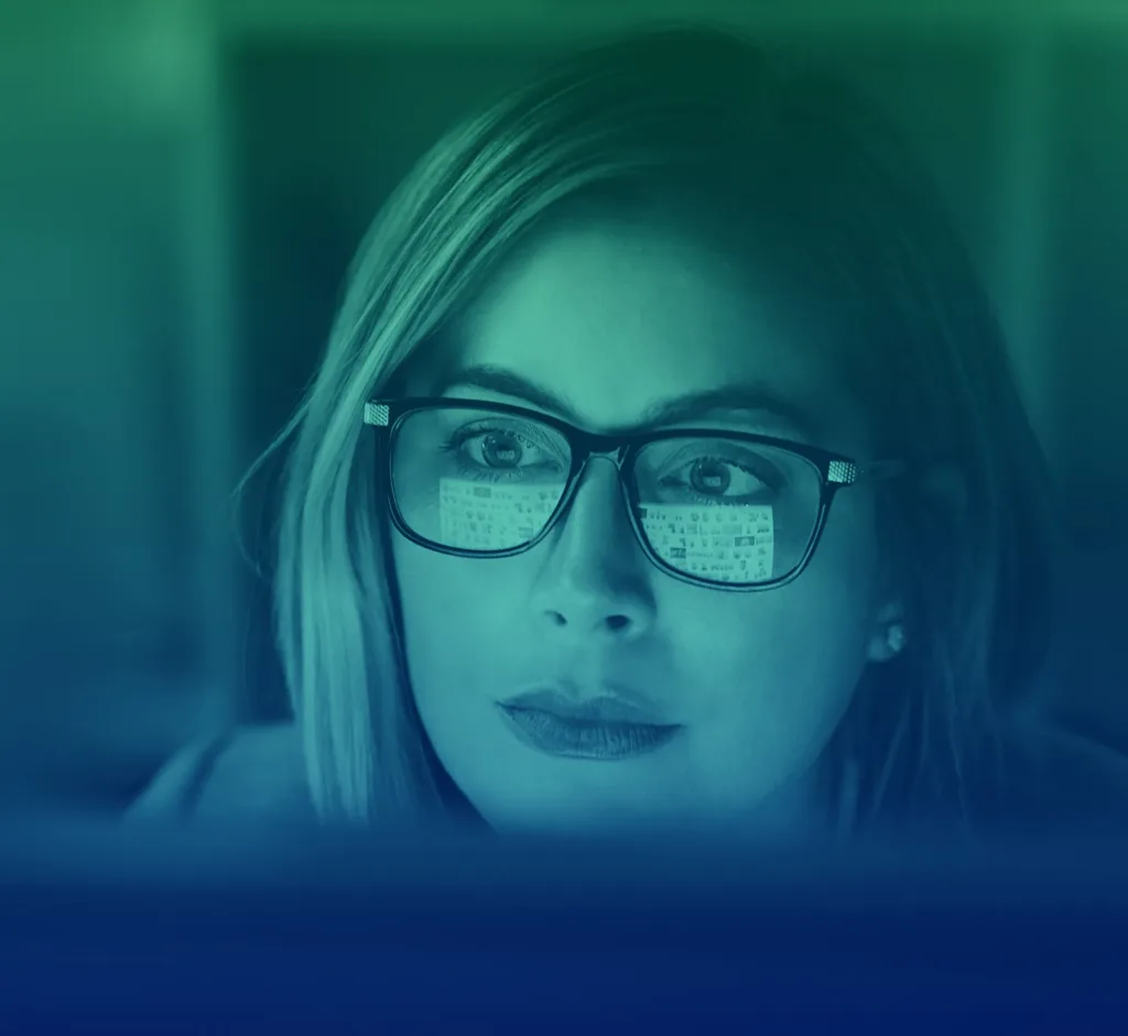 Woman from IDDI looks at information on a computer screen that reflects back in her glasses.